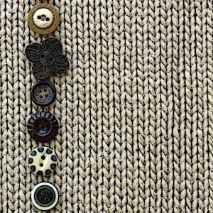 Row of Vintage Buttons Lined up on Soft Square Fabric Background